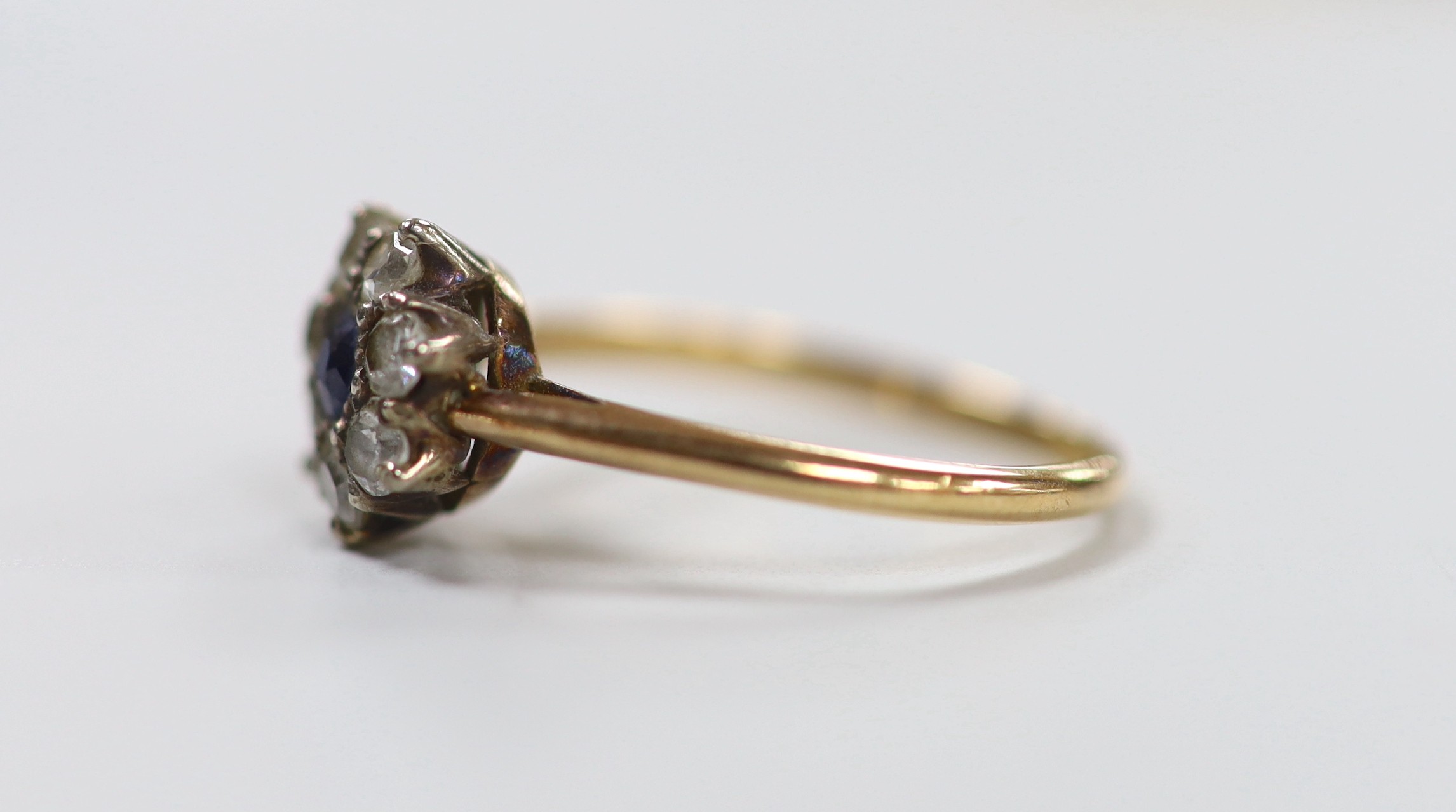 A yellow metal, sapphire and diamond set cluster ring, size N, gross weight 2.2 grams.
